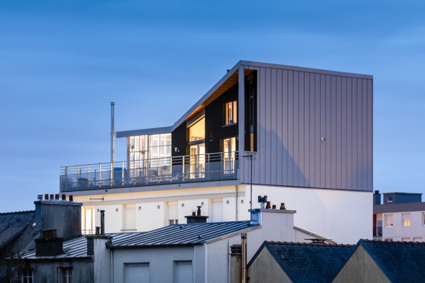 Photographie au crépuscule d'une surélévation en bois sur une copropriété à Brest. Photographie intégrée au dossier de retour d'expérience, réalisé par BATYLAB en mars 2023. Crédits : Pascal LEOPOLD, Photographe.